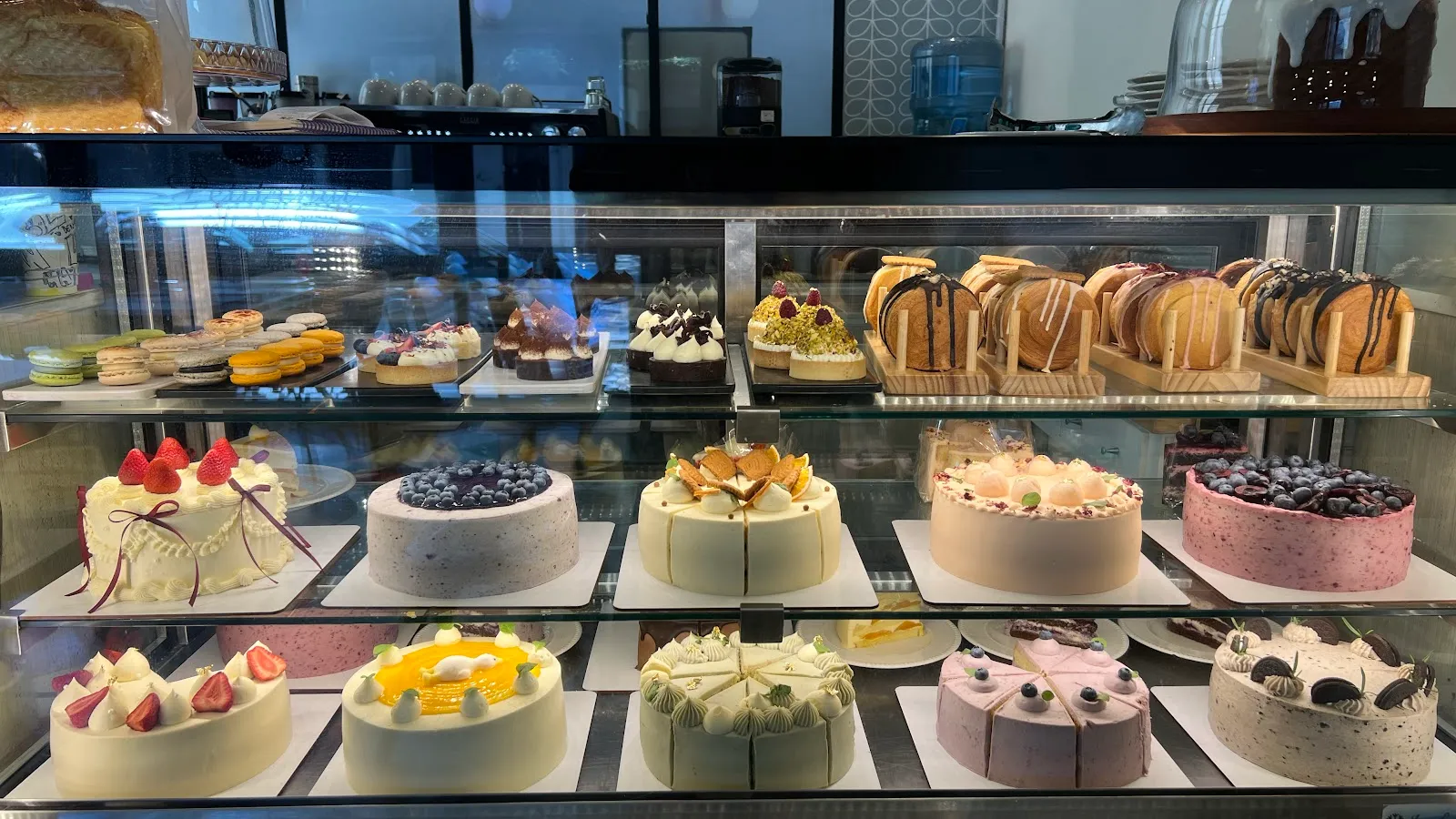 Mostrador refrigerado con tortas y postres en tonos pastel